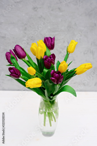 Wallpaper Mural Bouquet of purple and yellow spring tulip flowers in a glass vase on a light background. Mothers Day. International Women's Day. Torontodigital.ca