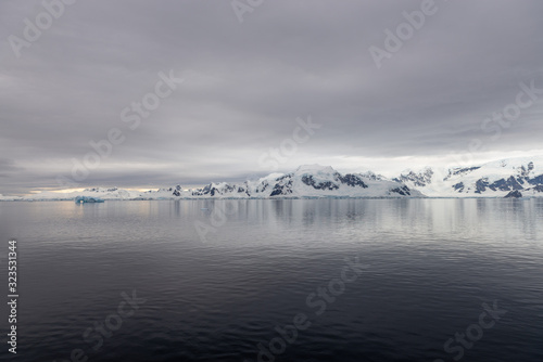 Antarctic beach with glacier and mountains, view from expedition ship