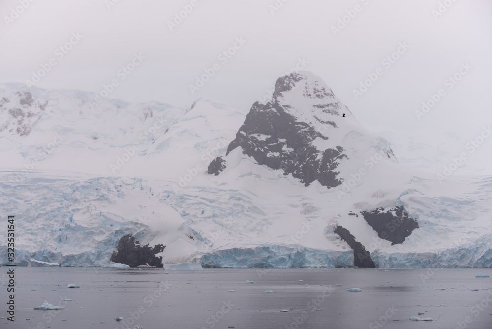 Antarctic beach with glacier and mountains, view from expedition ship