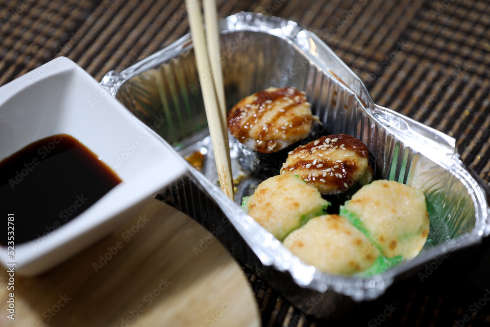 Take away sushi set on a brown background. Take away sushi set on a brown background.