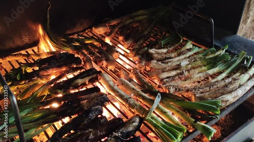 Cooking catalan calçots on the barbecue, typical sweet onions from Valls (Catalonia) photo