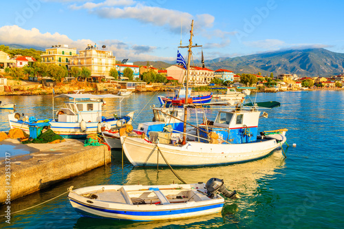 Greek fishing boats mooring at sunrise in Ireon port, Samos island, Greece