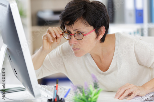 woman looking closely at computer screen