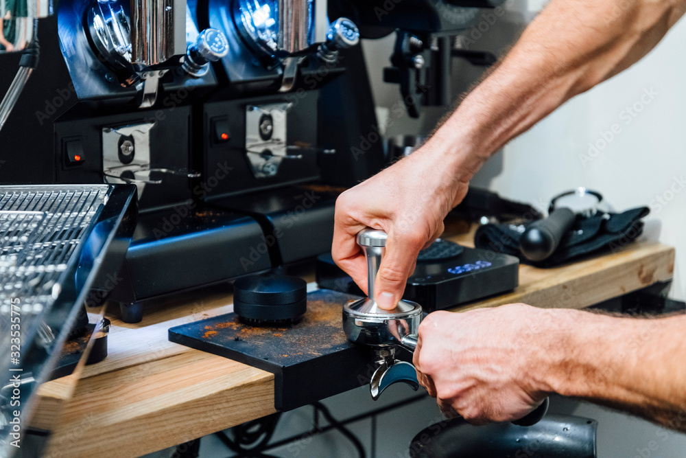 Barista pressing coffee to portafilter