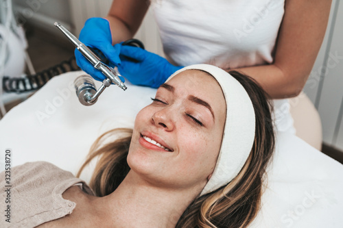 Beautiful young woman getting mesotherapy treatment at cosmetic beauty salon.