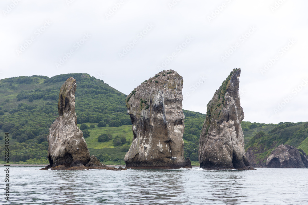 Three Brothers, Kamchatka Peninsula, Russia. A group of three pillar-shaped rocks protruding from the water (kekurs) located at the entrance to Avacha Bay.