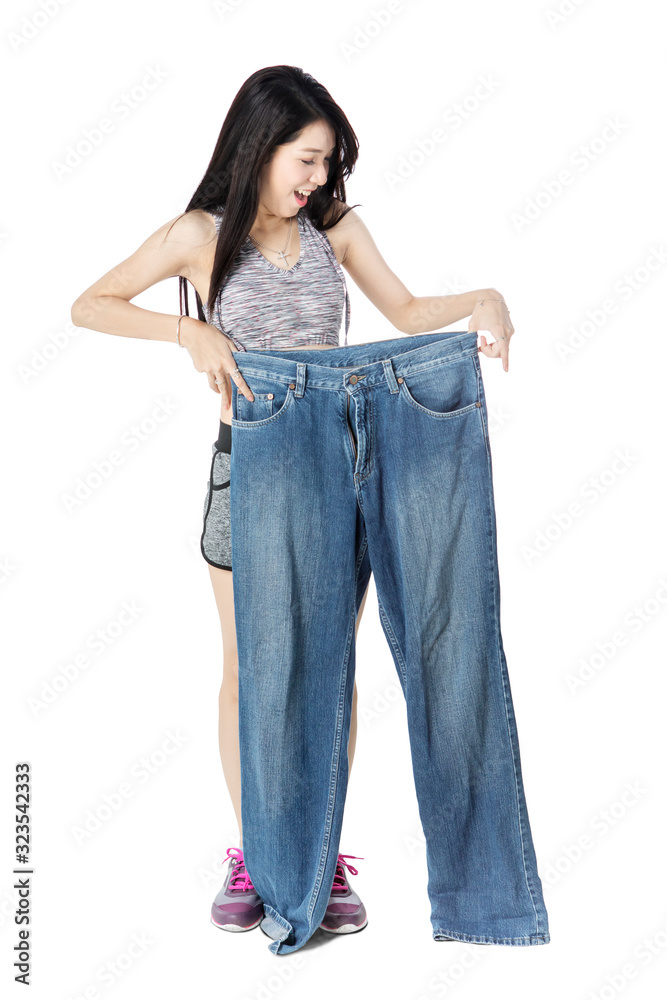 Happy young woman holding an old jeans Happy young woman holding an old jeans