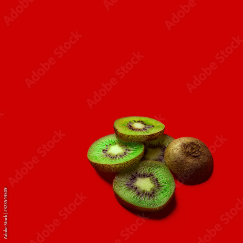 kiwi on a red background. Kiwi vitamins. Kiwi slices on a red background