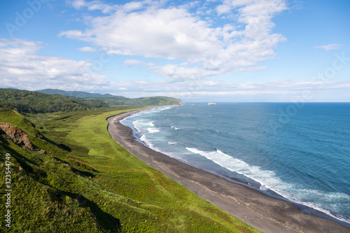 Wild beach made of volcanic sand on the Pacific Ocean, Kamchatka Peninsula, Russia.