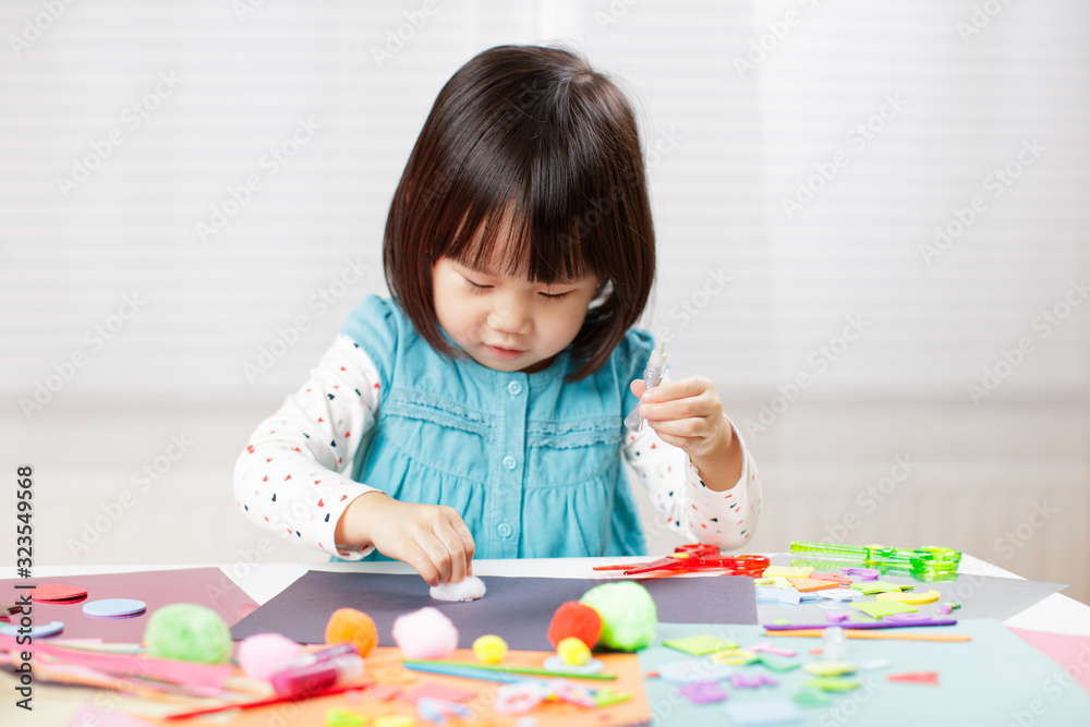 toddler girl learn making Origami at home against white background toddler girl learn making Origami at home against white background