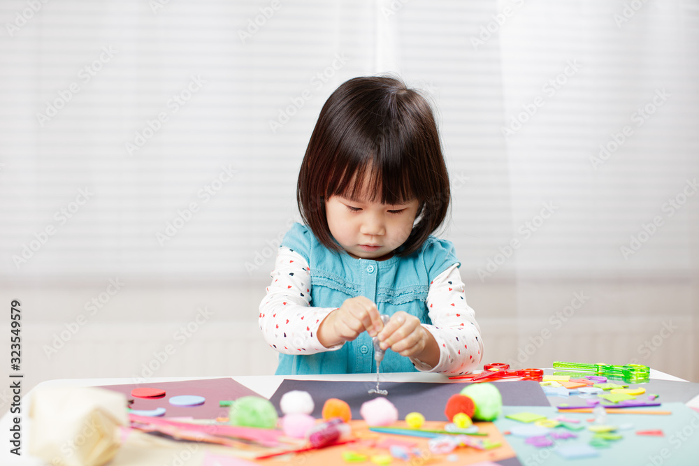 toddler girl learn making Origami at home against white background toddler girl learn making Origami at home against white background
