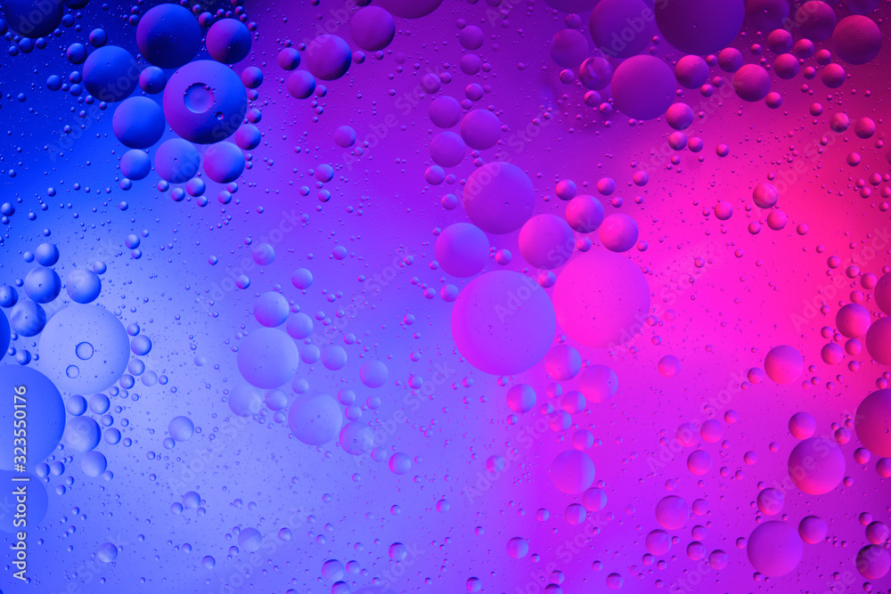 Oil drops on water surface color abstract background. blue and pink circles