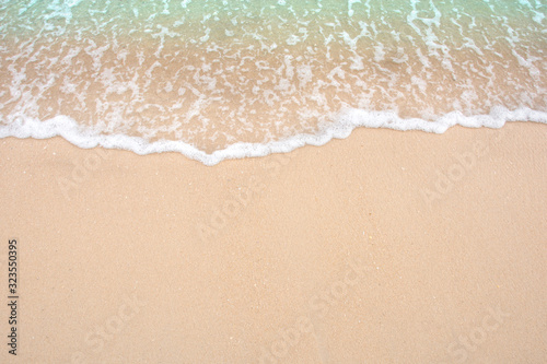 Summer beach concept - Soft wave of sea on empty sandy beach Background with copy space. © Achira22