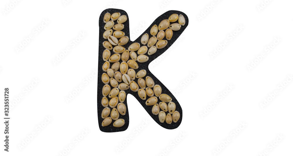 Isolated Font English or Latin Letter K or Russian letter К made of seashell on black granite on white background Isolated Font English or Latin Letter K or Russian letter К made of seashell on black granite on white background