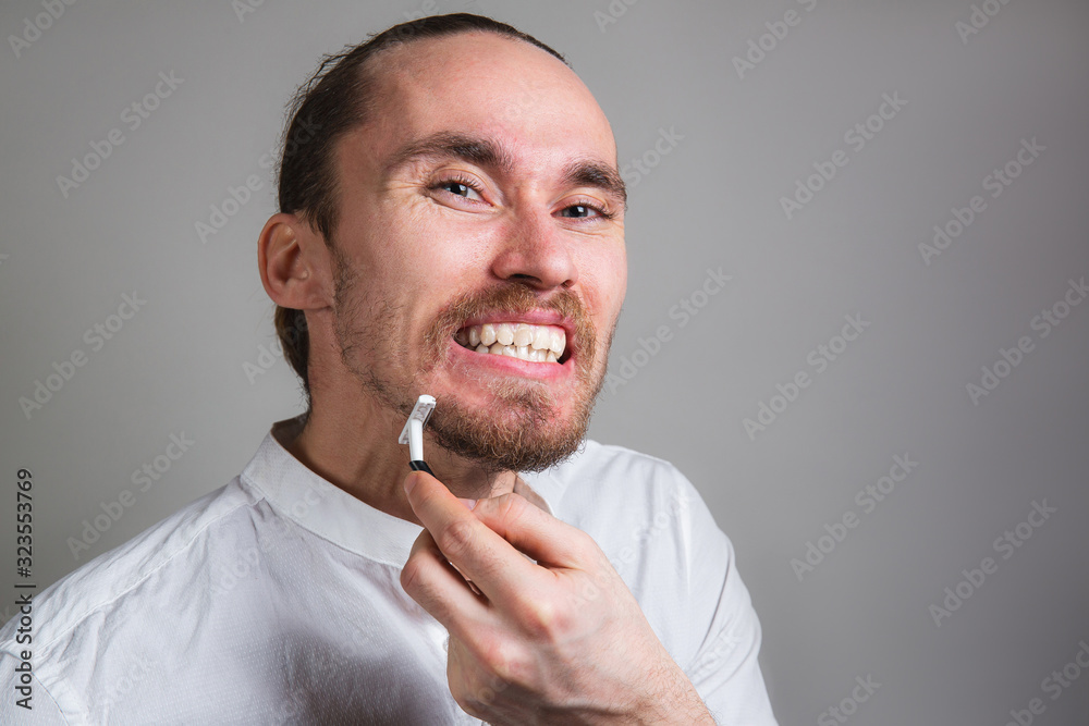 Angry manager shaving face in morning on gray background Angry manager shaving face in morning on gray background