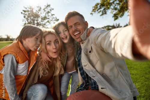 Having fun on weekend. Happy family taking selfies outdoors