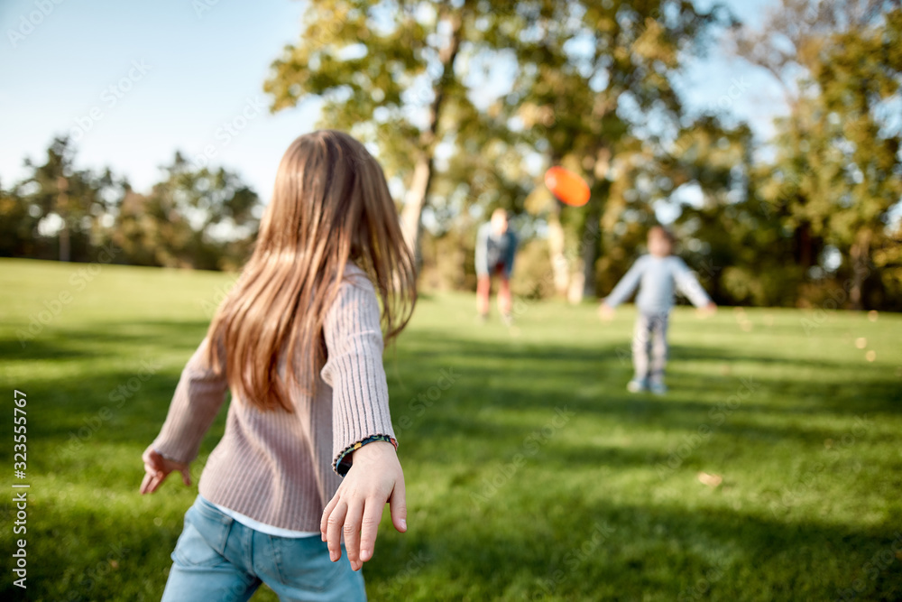 There is no better gift than a family. Little girl playing frisbee with her family in the park on a sunny day There is no better gift than a family. Little girl playing frisbee with her family in the park on a sunny day
