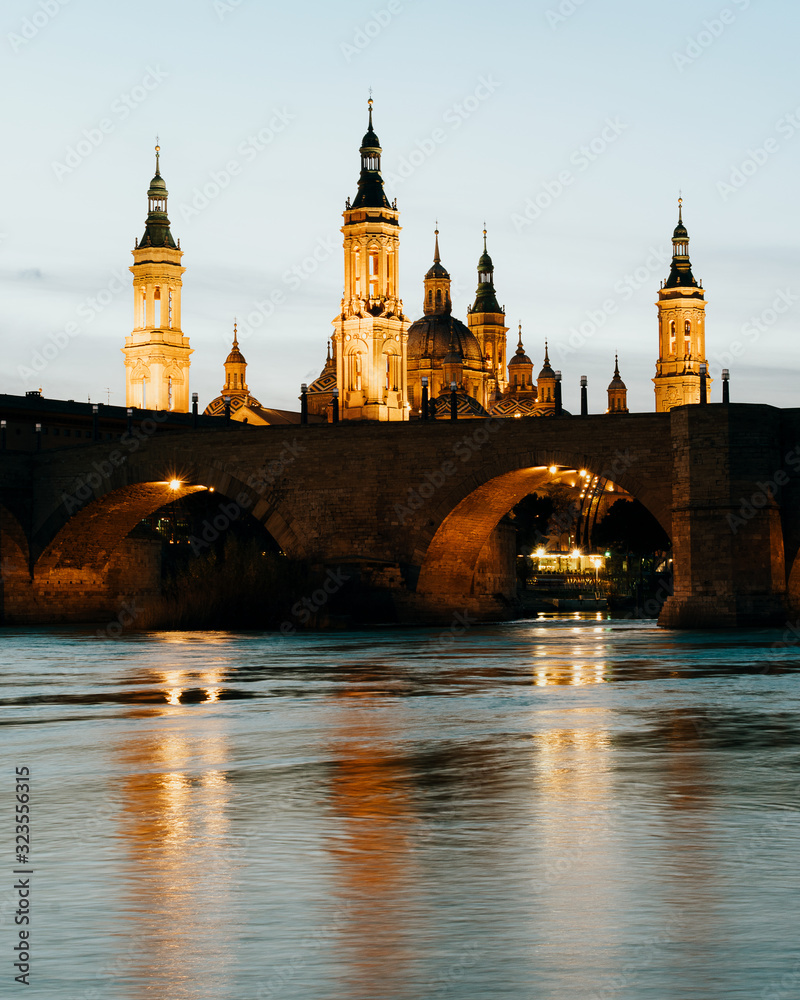 Basilica del Pilar and Puente de Piedra reflected in the Ebro river at sunset in Zaragoza, Aragon, Spain