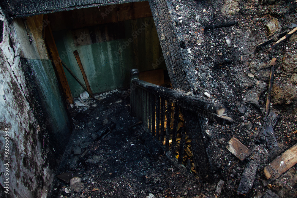 Consequences of fire in apartment house. Burnt interior and wooden staircase Consequences of fire in apartment house. Burnt interior and wooden staircase