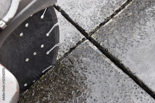 Concrete cutter machinery and cutting blade on a driveway