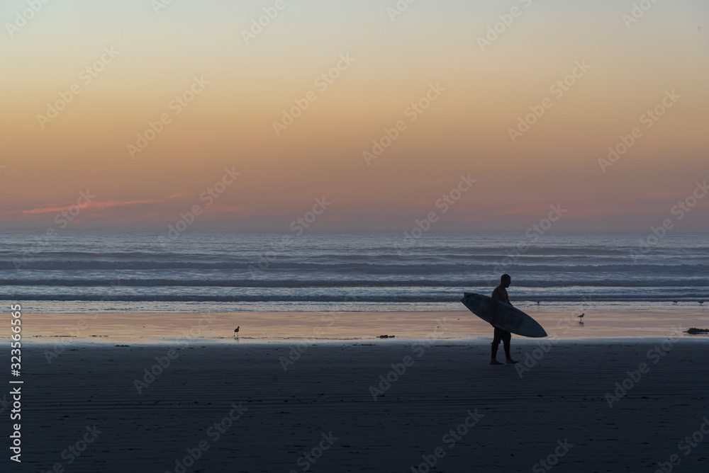 Surfer on the shore of the famous Pismo beach in California.