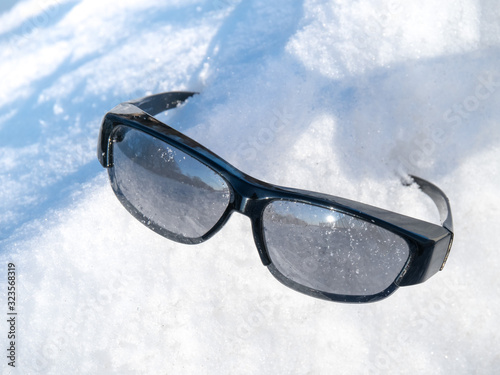 reflective sunglasses in a snow drift in winter © SockaGPhoto
