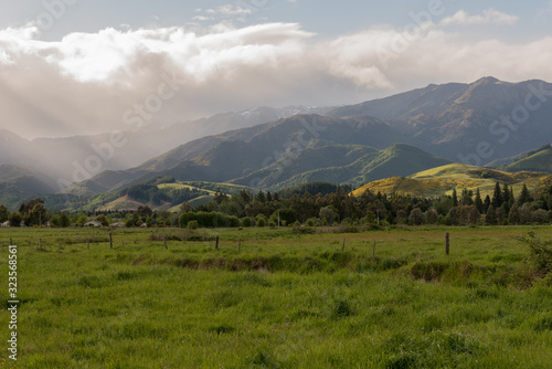 View of the mountains surrounding Hanmer Springs looking across farmland into the light at sunset. Hanmer Springs, Canterbury, New Zealand.