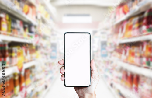 Using smartphone for shopping online on abstract supermarket background. Business online concept
