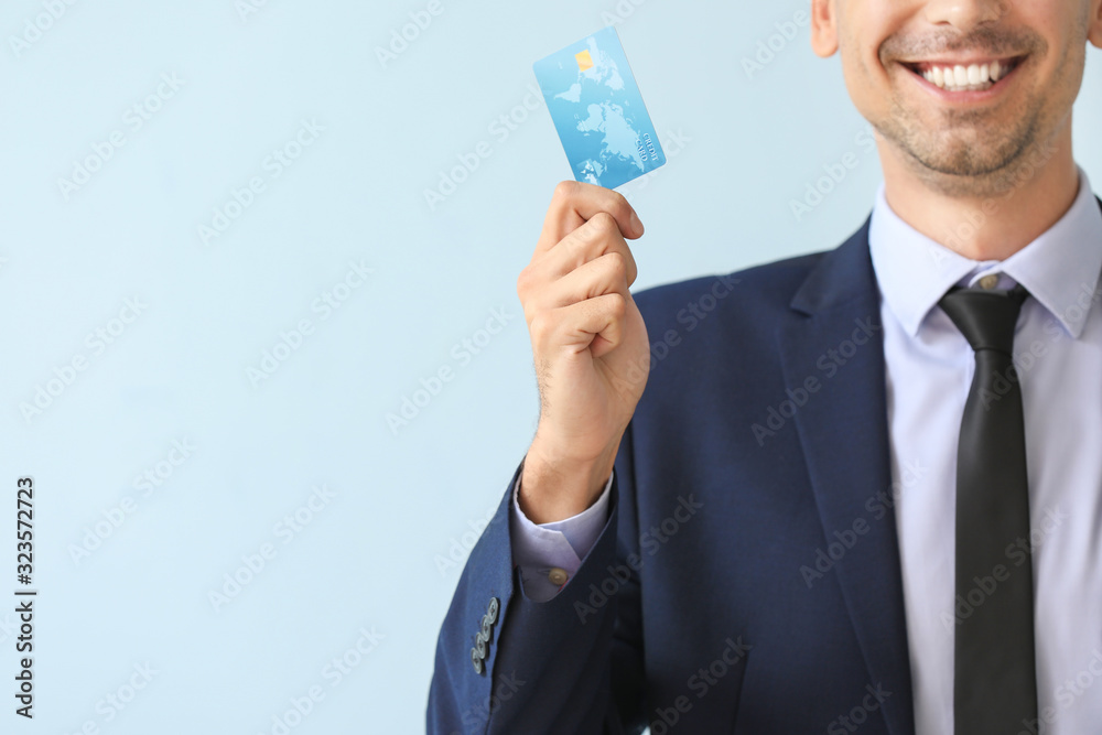 Male bank manager with credit card on light background Male bank manager with credit card on light background