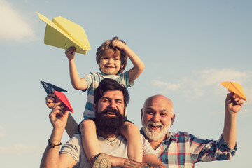 Grandfather with son and grandson having fun in park. Happy family. Grandfather playtime. Father and son playing on blue summer sky.