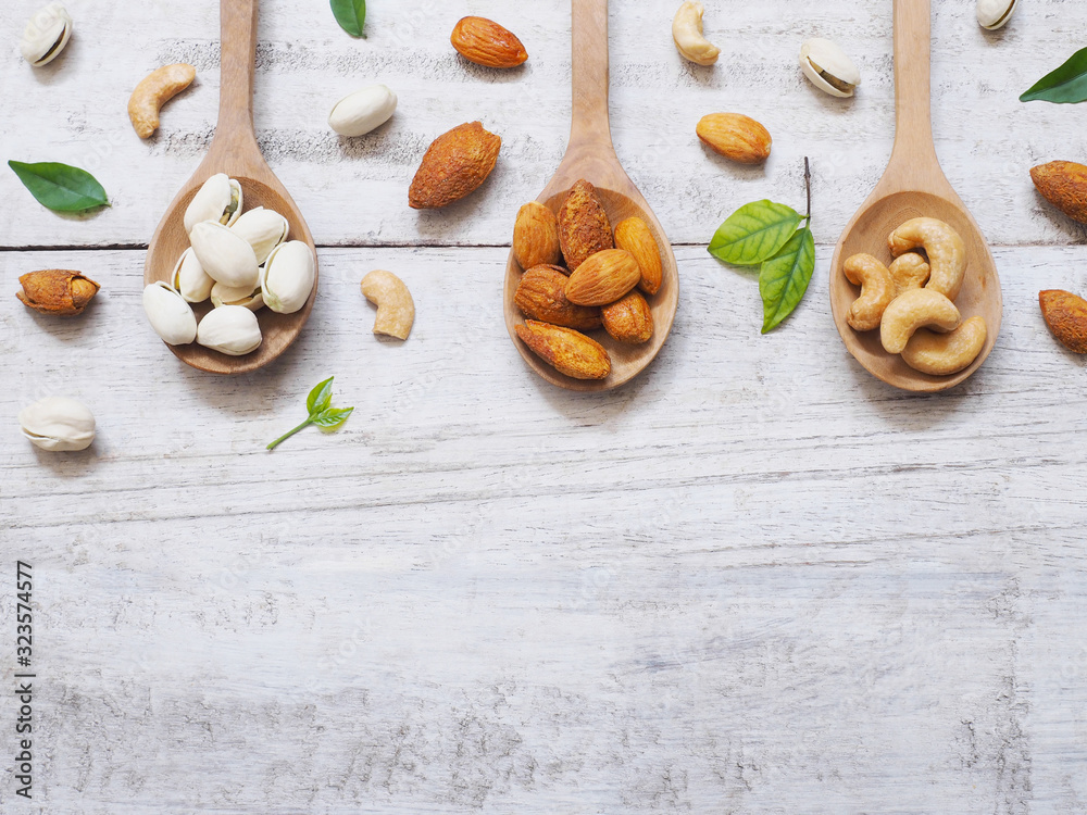  mixed dried nut in wooden spoon on wood background.