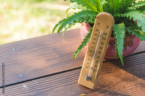 Foto Outdoor wood thermometer calibrated in celsius and fahrenheit scale showing 15 d