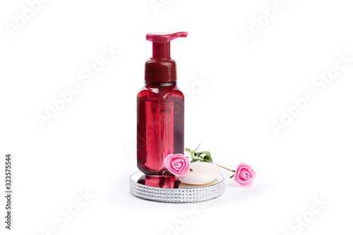 red bath accessories, body wash, and a bar of facial soap on a mirror tray isolated on white