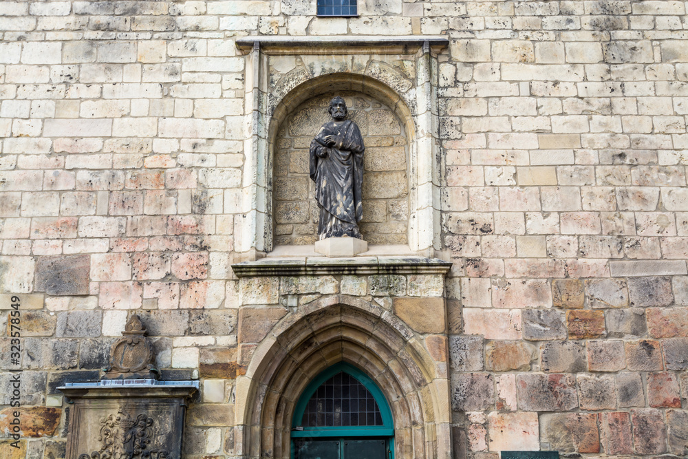 Statue on the wall of the Die kreuzkirche church, a gothic style building  in Hannover, Germany.
