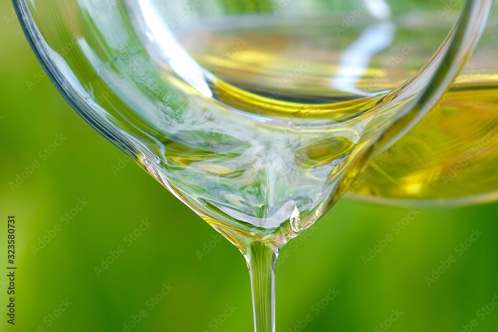Pouring olive oil in the a glass bowl at stone kitchen and inside green garden view. Prepare for cooking concept. Healthcare and Beauty Concept. Pouring olive oil in the a glass bowl at stone kitchen and inside green garden view. Prepare for cooking concept. Healthcare and Beauty Concept.