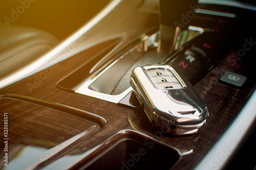 The car keyless remote is chrome color placed at the luxury car console. photo
