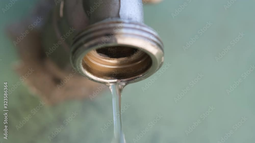 Water droplets flowing from the tap, water saving concept Water droplets flowing from the tap, water saving concept
