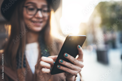 Woman holding in hands mobile phone crop. Close up technology smartphone online connect. Girl tourist in glasses using gadget cellphone in sun flare city. Digital internet lifestyle mockup