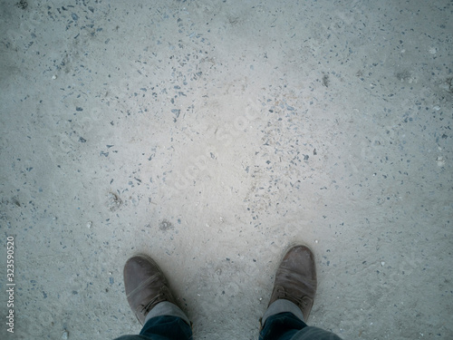 man should brown boots and jean on crement ground, stand on the concrete floor, We must consider who this trap is for, out of one's head, To examine something very carefully in order to discover infor photo