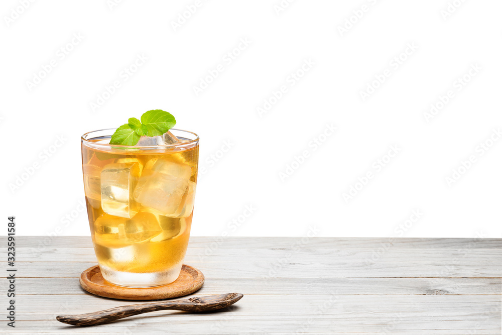 Tea or yellow herbal in a glass with ice And Peppermint added a fragrance on the wooden table Isolated on white background Tea or yellow herbal in a glass with ice And Peppermint added a fragrance on the wooden table Isolated on white background