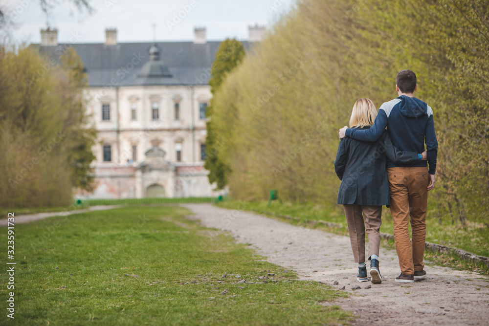 Obraz premium couple walking by alley in front of old beauty castle