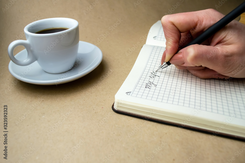Writing in a notebook My life is a nearby cup of coffee Writing in a notebook My life is a nearby cup of coffee