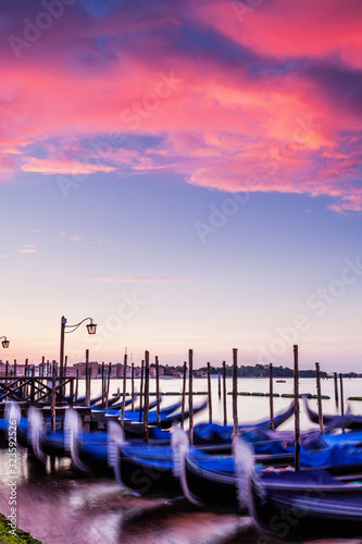 Gondolas under a vibrant sunset sky in Venice