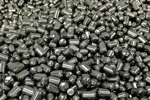 Tungsten cylinders. Ingots of tungsten in a pile. photo