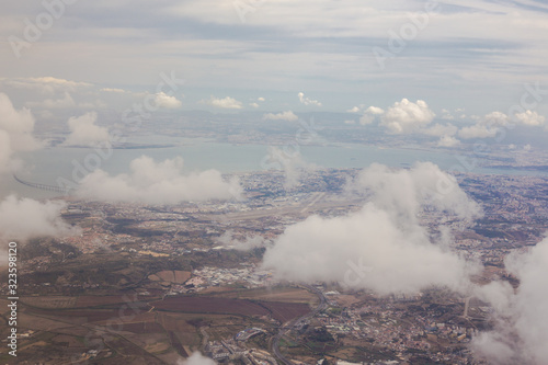 View from the porthole of an airplane. Clouds over Lisbon.