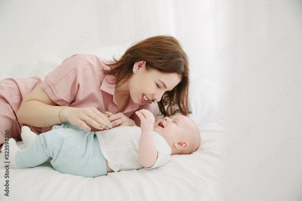 Portrait of happy young mother and baby lying on the bed at home Portrait of happy young mother and baby lying on the bed at home