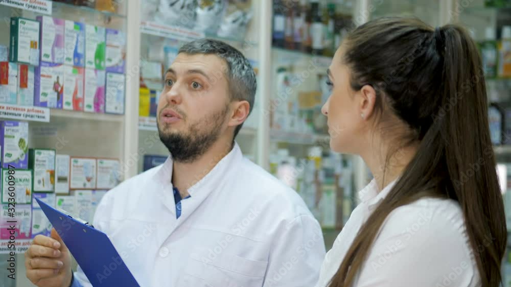 Two young promoters makes a reconciliation of drugs in a pharmacy Two young promoters makes a reconciliation of drugs in a pharmacy