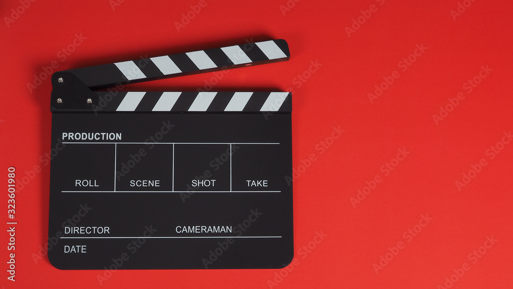 Naklejka premium clapperboard or clapper board movie slate .It is use in video and cinema industry on red background.