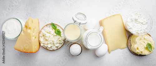 Fresh dairy products, milk, cottage cheese, eggs, yogurt, sour cream and butter on white background, top view