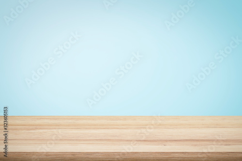 Fototapeta Empty wooden deck table over light blue wallpaper background for present product